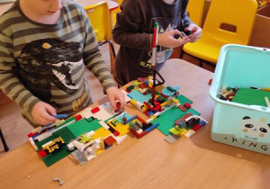 Wojtek G. z Radkiem tworzą budowle z klocków Lego.